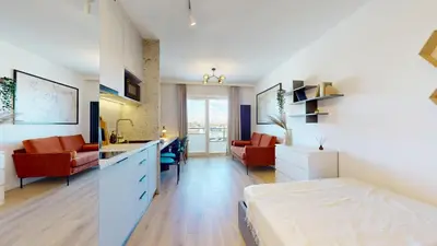 a bedroom with a bed and a kitchen and a living room at Apartamenty na Pana Tadeusza in Kraków