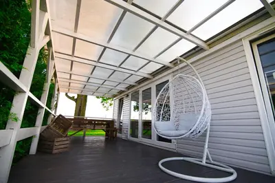 a porch with a swinging chair on a patio at Skandynawia Przystań & Family Resort in Zator