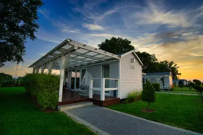a white house with a pergola in a yard at Skandynawia Przystań & Family Resort in Zator