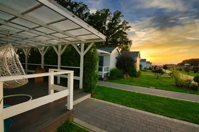 a porch with a white pergola and a swing at Skandynawia Przystań & Family Resort in Zator