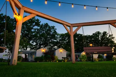 a swing in a yard at night with lights at Skandynawia Przystań & Family Resort in Zator