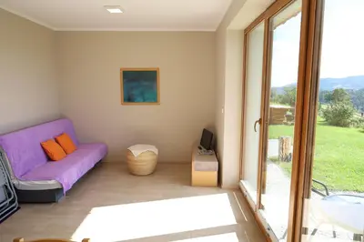 a living room with a purple couch and a sliding glass door at Las Góra Natura in Laskowa