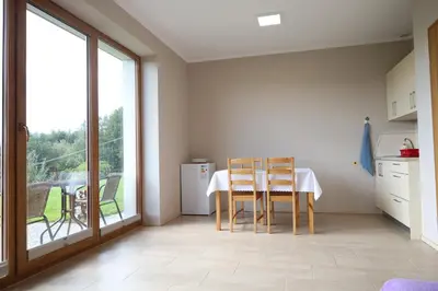 a kitchen with a table and chairs and a window at Las Góra Natura in Laskowa