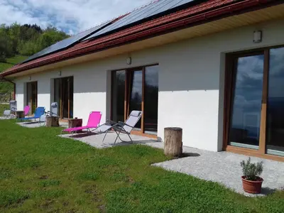 a house with chairs sitting outside of it at Las Góra Natura in Laskowa