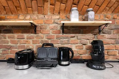 a restaurant with a brick wall and tables and chairs at Apart HOSTEL - KrakHouse in Kraków