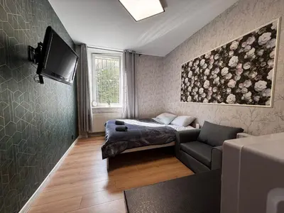 a bedroom with a bed and a desk and a window at Apart HOSTEL - KrakHouse in Kraków