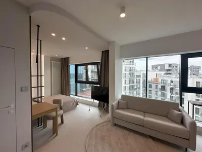 a living room with a couch and a bed and windows at Aga Apartments Cracow Old Town in Kraków