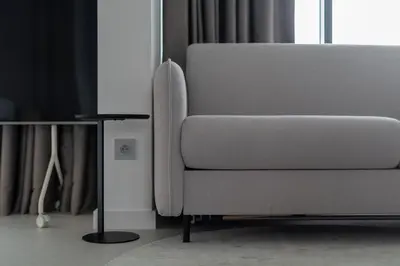 a grey couch in a living room with a television at Aga Apartments Cracow Old Town in Kraków
