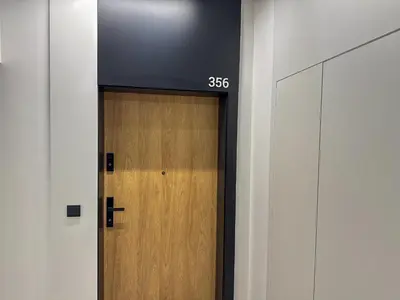 a door in a hallway with a tv above it at Aga Apartments Cracow Old Town in Kraków