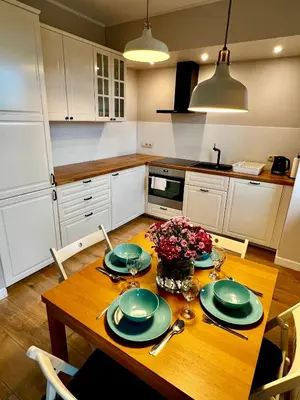 a kitchen with a wooden table with green plates on it at Apartament Gucio in Zator