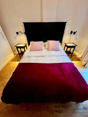 a bedroom with a large bed with two tables at Apartament Gucio in Zator