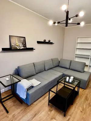 a living room with a blue couch and two tables at Apartament Gucio in Zator