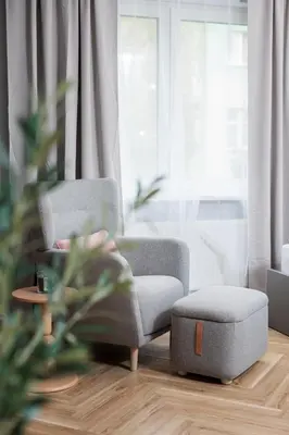 a living room with two chairs and a ottoman at Monika Apartments by Upstairs in Kraków