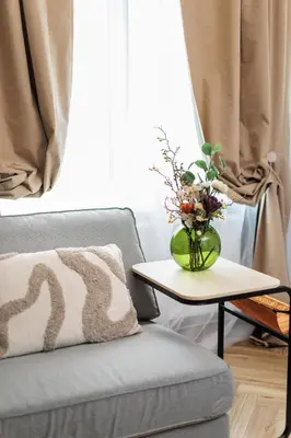 a vase of flowers on a table next to a couch at Monika Apartments by Upstairs in Kraków