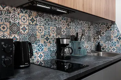 a kitchen with a sink and a tile wall at Monika Apartments by Upstairs in Kraków
