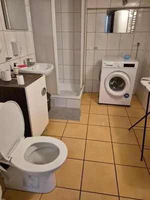 a bathroom with a toilet and a washing machine at Pokoj u Eleni #2 in Kraków