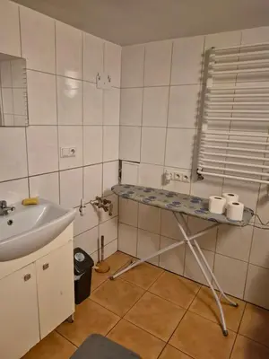 a small bathroom with a sink and a table at Pokoj u Eleni #1 in Kraków