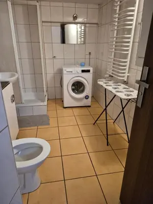 a bathroom with a toilet and a washing machine at Pokoj u Eleni #1 in Kraków