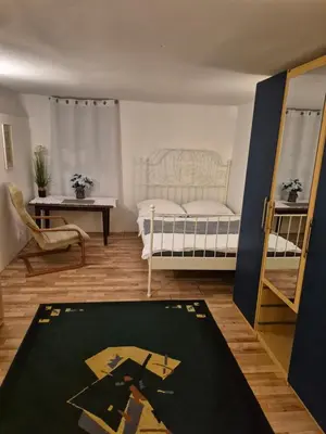 a bedroom with a bed and a table and a rug at Pokoj u Eleni #1 in Kraków