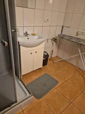 a small bathroom with a sink and a shower at Pokoj u Eleni #5 in Kraków