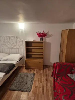 a bedroom with a bed and a dresser with flowers on it at Pokoj u Eleni #5 in Kraków