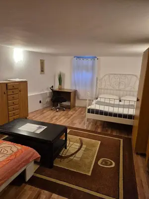 a living room with a bed and a desk at Pokoj u Eleni #3 in Kraków