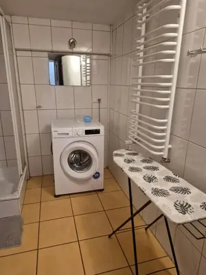 a small bathroom with a washing machine and a table at Pokoj u Eleni #3 in Kraków