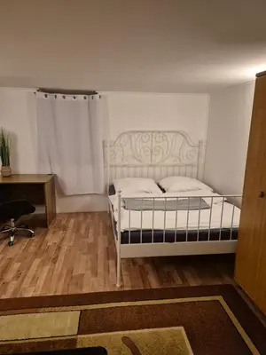 a bedroom with a white bed and a desk at Pokoj u Eleni #3 in Kraków