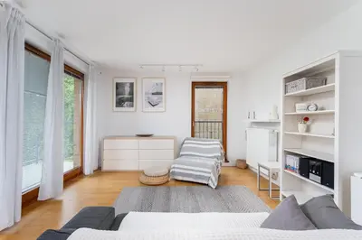 a hallway with stairs and white walls and a stair case at Wilga Park Homely Apartment by BookingHost in Kraków