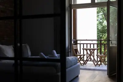 a room with a couch and a balcony with a table at Tyzenhauz Apartments Superior in Kraków