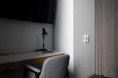 a room with a desk with a chair and a lamp at Tyzenhauz Apartments Superior in Kraków