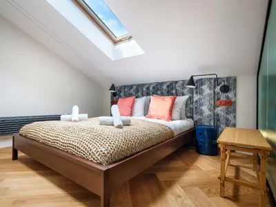 a bedroom with a large bed with orange pillows at Tyzenhauz Apartments Superior in Kraków