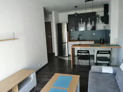 a kitchen and living room with a table and chairs at Fajny Apartament EXPO TAURON ARENA in Kraków