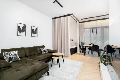 a living room with a couch and a table at Kościuszki Chic Studio with Garden by BookingHost in Kraków