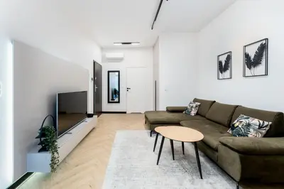 a living room with a couch and a table at Kościuszki Chic Studio with Garden by BookingHost in Kraków