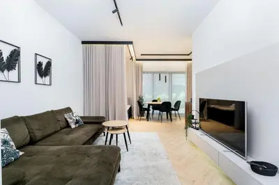 a living room with a couch and a table at Kościuszki Chic Studio with Garden by BookingHost in Kraków