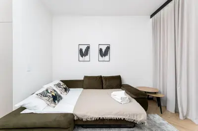 a white room with a bed and a couch at Kościuszki Chic Studio with Garden by BookingHost in Kraków
