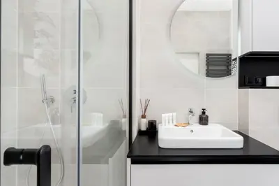 a white bathroom with a sink and a shower at Kościuszki Chic Studio with Garden by BookingHost in Kraków