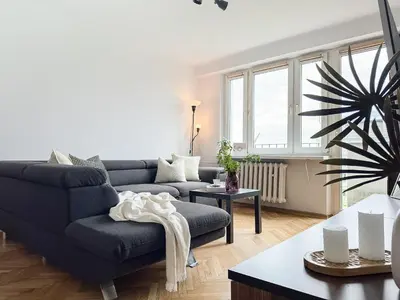 a living room with a blue couch and a table at Vista Kraków Ugorek in Kraków