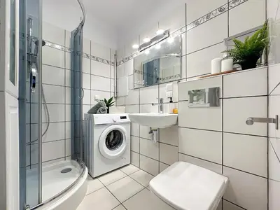 a bathroom with a washing machine and a sink at Vista Kraków Ugorek in Kraków