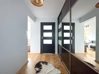 a hallway with a dog laying on a rug in front of a door at Vista Kraków Ugorek in Kraków