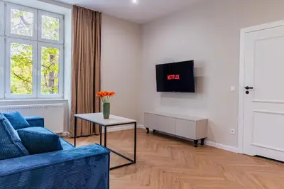 a living room with a blue couch and a tv at Między Wawelem a Rynkiem in Kraków