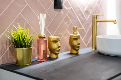 a bathroom counter with three gold vases and a sink at Między Wawelem a Rynkiem in Kraków