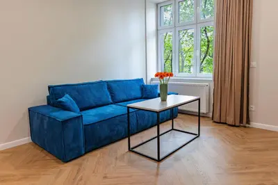 a blue couch in a living room with a table at Między Wawelem a Rynkiem in Kraków