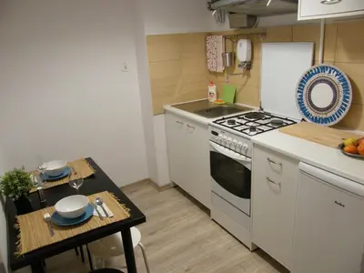 a small kitchen with a stove and a table at Apartament Jagielloński in Kraków