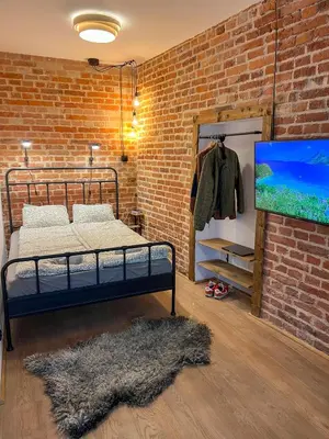 a bedroom with a bed and a brick wall at CracoviaStay Lofty Apartment Old Town Kazimierz Historic Heart of Krakow in Kraków
