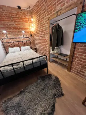a room with a bed and a brick wall at CracoviaStay Lofty Apartment Old Town Kazimierz Historic Heart of Krakow in Kraków