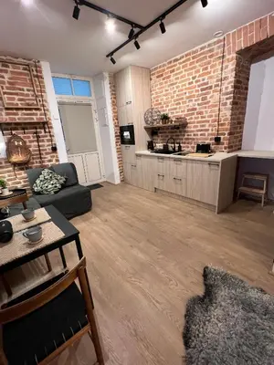 a large living room with a brick wall at CracoviaStay Lofty Apartment Old Town Kazimierz Historic Heart of Krakow in Kraków