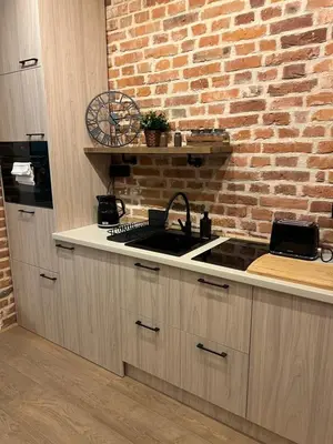 a kitchen with a sink and a brick wall at CracoviaStay Lofty Apartment Old Town Kazimierz Historic Heart of Krakow in Kraków