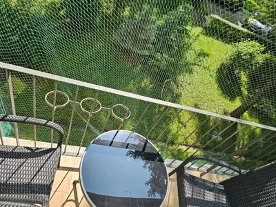 a mirror sitting on a balcony with two chairs at Apartamenty Asia Kraków in Kraków